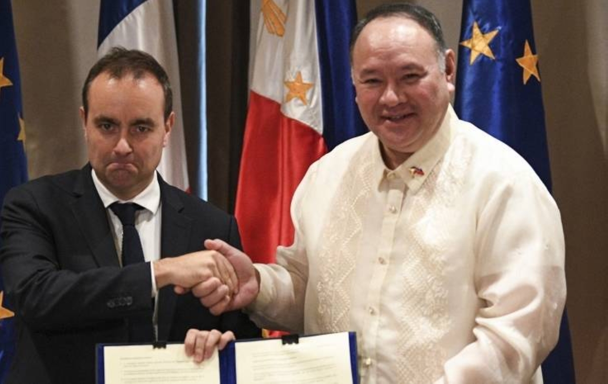 France's Minister for the Armed Forces Sebastien Lecornu (L) shakes hands with Secretary of National Defense of Philippines Gilbert Teodoro after signing documents at a hotel in Manila on December 2, 2023. AFP PHOTO