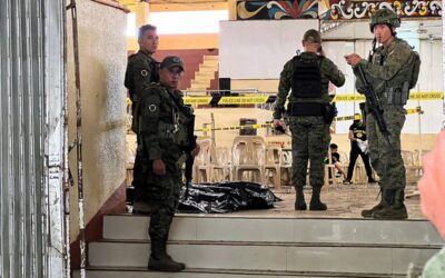 Military personnel stand guard at the entrance of a gymnasium while police investigators (background) look for evidence after a bomb attack at Mindanao State University in Marawi, Lanao del sur province on December 3, 2023.
