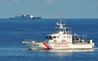 (FILES) This file photo taken on May 14, 2019 shows a Philippines' coast guard ship (R) sailing past a Chinese coast guard ship during a joint search and rescue exercise between the Philippines and US coast guards near Scarborough Shoal in the South China Sea. - The Scarborough Shoal fishing ground, tapped by generations of Filipino fishermen, is one of many potential flashpoints for military conflict over the South China Sea. China and Taiwan both claim sovereignty over almost the entire sea, while the Philippines, Vietnam, Malaysia and Brunei have competing claims to parts of it. (Photo by Ted ALJIBE / AFP) / TO GO WITH China-Xi-congress-Philippines-fishing, FOCUS by Allison JACKSON