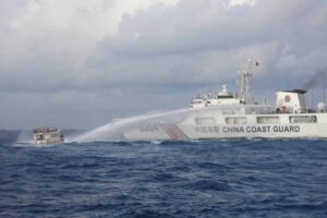 This handout photo taken and released on Dec. 10, 2023, by the Philippine Coast Guard (PCG) shows a China Coast Guard vessel (right) using water cannon against the M/L Kalayaan chartered supply boat during a mission to deliver provisions at Second Thomas Shoal in disputed waters of the South China Sea (SCS). A Philippine boat was 'rammed' by a Chinese coast guard ship during a resupply mission on Sunday, the PCG said, in the latest such confrontation in the disputed SCS. AFP