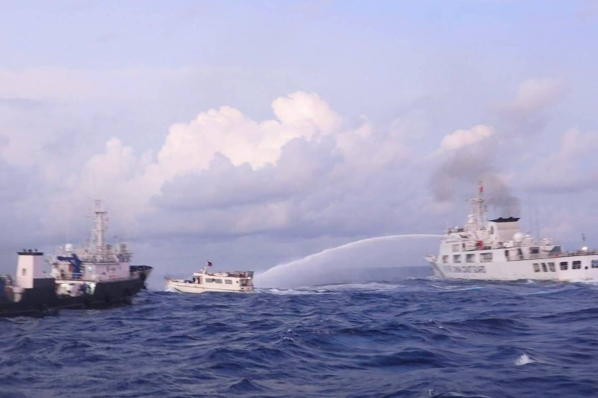 This handout photo taken and released on December 10, 2023 by the Philippine Coast Guard (PCG) shows a China Coast Guard vessel (right) using water cannon against the M/L Kalayaan chartered supply boat (center) during a mission to deliver provisions at Ayungin Shoal in disputed waters of the South China Sea. AFP PHOTO /  PHILIPPINE COAST GUARD