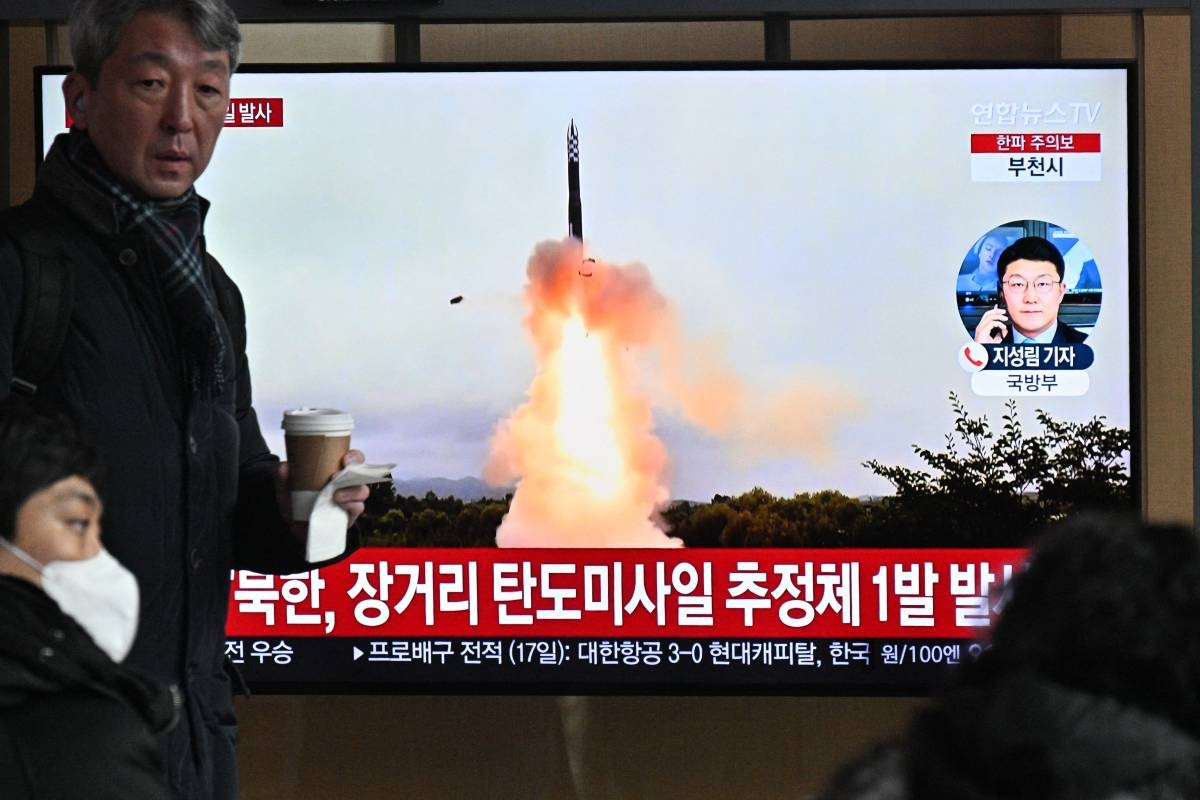 A man walks past a television screen showing a news broadcast with file footage of a North Korean missile test, at a railway station in Seoul on December 18, 2023. AFP PHOTO