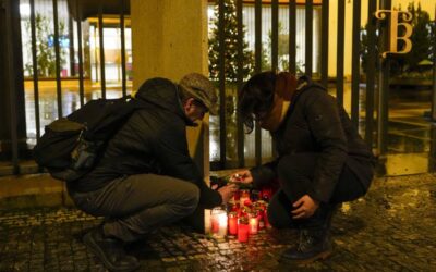 SMALL SHRINE A man assists a woman in lighting a candle outside the building of the Philosophical Faculty of Charles University in downtown Prague, Czech Republic, following a mass shooting there on Thursday, Dec. 21, 2023. AP PHOTO