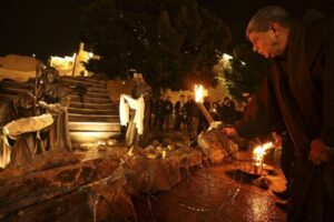 SOMBER CELEBRATION A priest places a candle in front of a nativity scene installed with rubble — in reference to the war in Gaza — in front of the Church of the Nativity in the city of Bethlehem in the occupied West Bank on Saturday, Dec. 23, 2023. AFP PHOTO