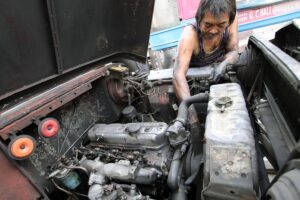 Warlito Clarito, 64, conducts maintenance work on a cooperative-owned passenger jeepney he drives on Wednesday, Dec. 27, 2023. When asked what he will do on December 31, the deadline for mandatory franchise consolidation that could hinder traditional jeepney drivers and operators from continuing their operations, Clarito said that his fellow drivers and operators should collectively stand against the impending jeepney phaseout as this is their only source of livelihood. PHOTO BY MIKE DE JUAN
