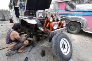 Warlito Clarito, 64, conducts maintenance work on a cooperative-owned passenger jeepney he drives on Wednesday, Dec. 27, 2023. When asked what he will do on December 31, the deadline for mandatory franchise consolidation that could hinder traditional jeepney drivers and operators from continuing their operations, Clarito said that his fellow drivers and operators should collectively stand against the impending jeepney phaseout as this is their only source of livelihood. PHOTOS BY MIKE DE JUAN