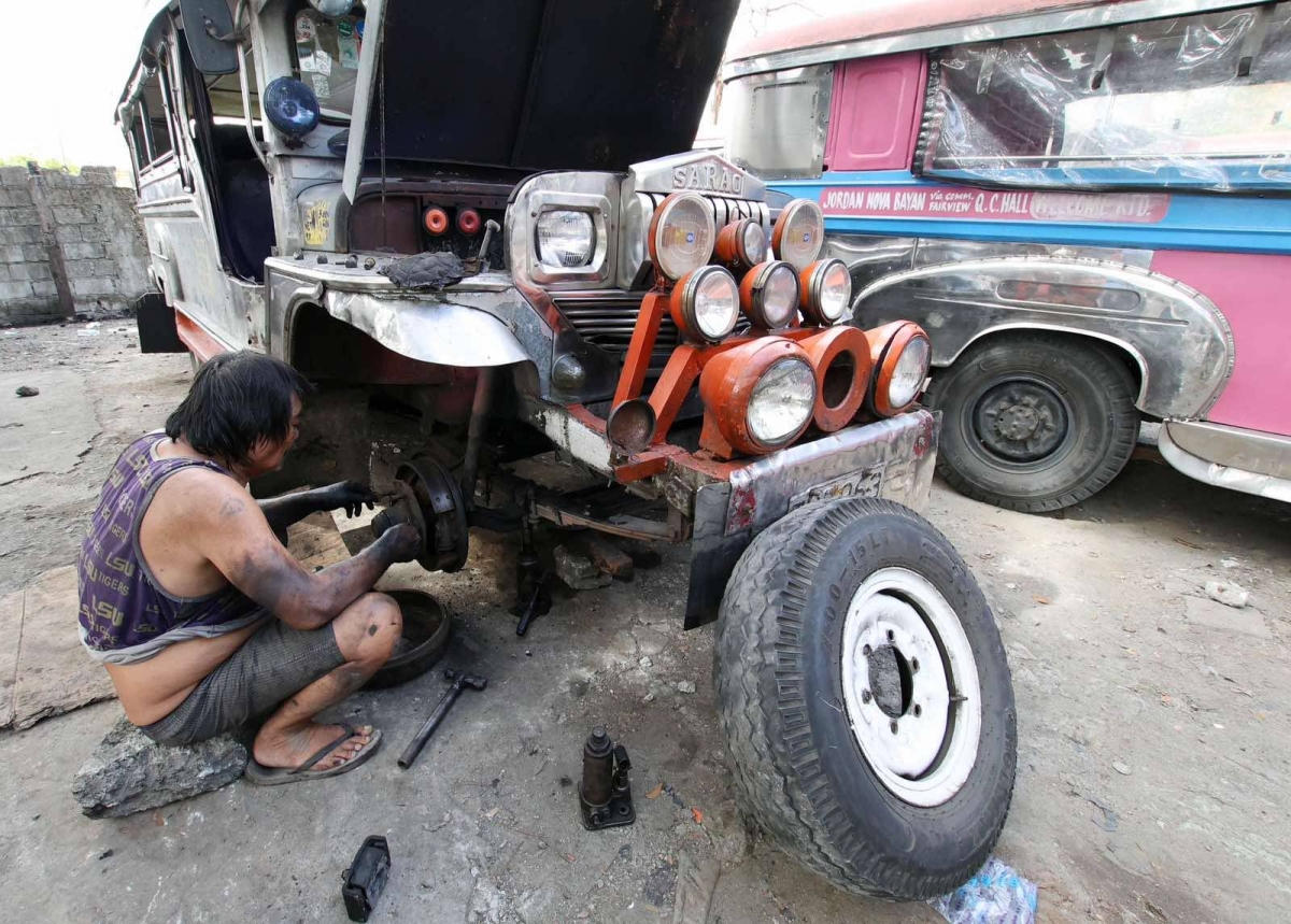 Warlito Clarito, 64, conducts maintenance work on a cooperative-owned passenger jeepney he drives on Wednesday, Dec. 27, 2023. When asked what he will do on December 31, the deadline for mandatory franchise consolidation that could hinder traditional jeepney drivers and operators from continuing their operations, Clarito said that his fellow drivers and operators should collectively stand against the impending jeepney phaseout as this is their only source of livelihood. PHOTOS BY MIKE DE JUAN