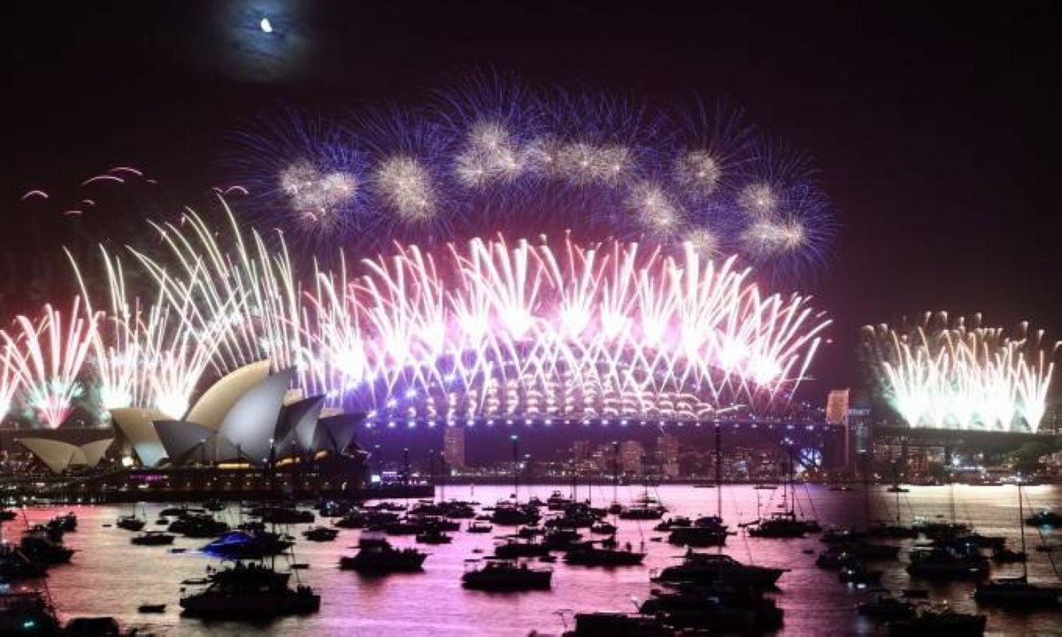 New Year's Eve fireworks light up the sky over the Sydney Opera House (L) and Harbour Bridge during the fireworks display in Sydney on January 1, 2023. (Photo by DAVID GRAY / AFP)