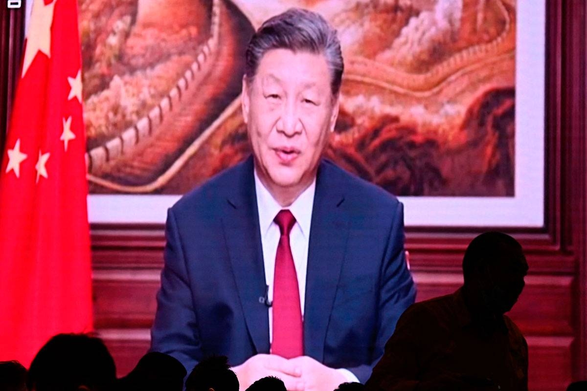 People have their dinner at a restaurant as a screen broadcasts China's President Xi Jinping while delivering his New Year's speech in Beijing on December 31, 2023. Pedro Pardo / AFP