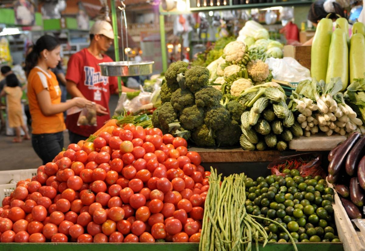A customers buys vegetables in a farmers market in Quezon City. Food inflation fell to 5.5 percent from 5.8 percent in November, which the PSA attributed to a 9.2-percent drop in the prices of vegetables, tubers, plantains, cooking bananas and pulses. AFP PHOTO/Jay DIRECTO