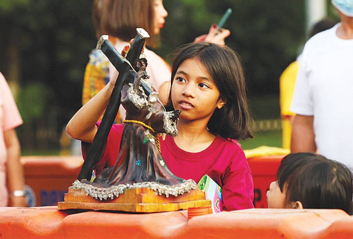 ‘LET THE CHILDREN COME’ A child puts a replica of the Black Nazarene on top of a barrier as she awaits her turn for the traditional ‘Pahalik’ where devotees are allowed to kiss the image of the Nazareno at the Quirino Grandstand in Manila on Saturday, Jan. 6, 2024, ahead of the Traslacion or procession on Tuesday, January 9. PHOTO BY RIO DELUVIO