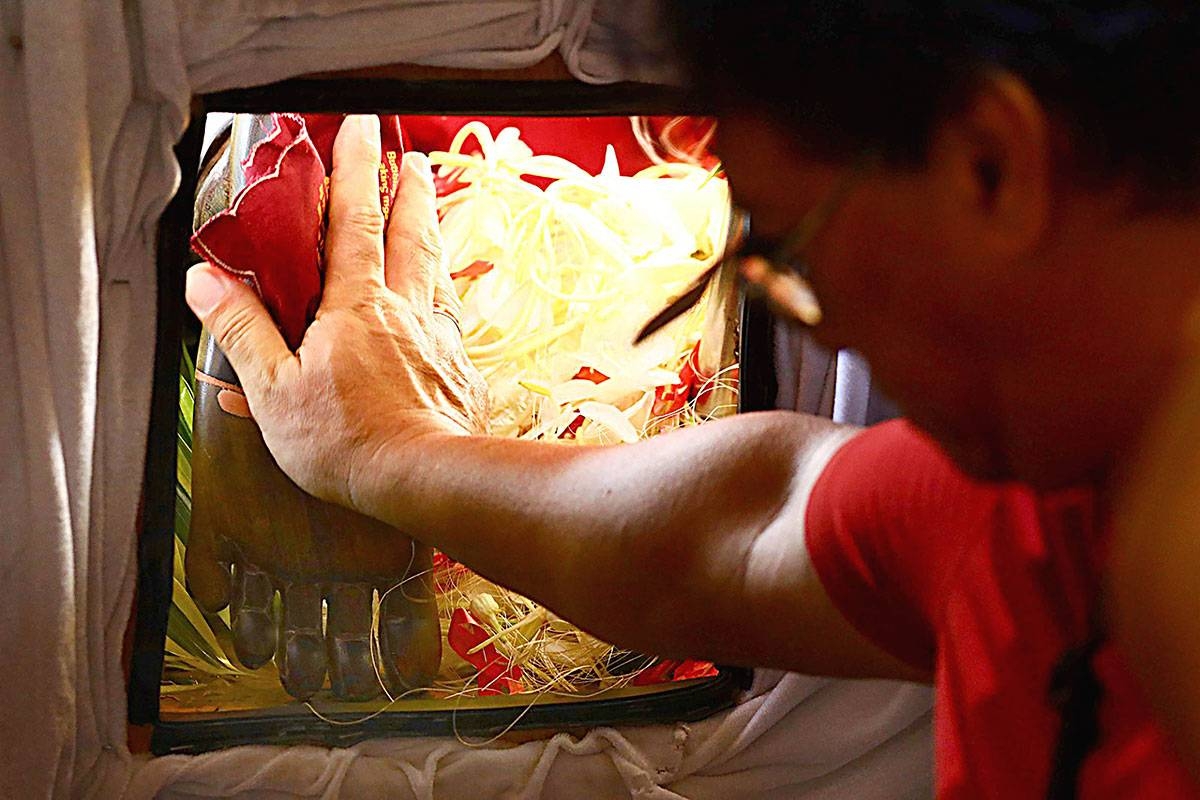 Keeping the faith A devotee prays as he holds the foot of the Black Nazarene at the Quirino Grandstand in Manila on Monday, Jan. 8, 2024. PHOTO BY MIKE ALQUINTO