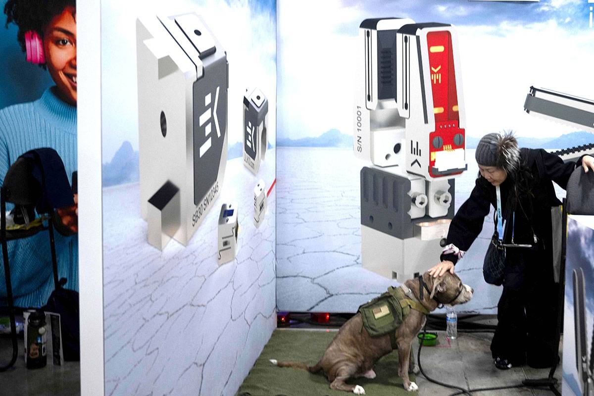 A woman pets a dog staying with her in a booth at the Eureka Park exhibition in the Venetian Expo Center during the Consumer Electronics Show on Tuesday, Jan. 9, 2024, in Las Vegas, Nevada. AFP PHOTO