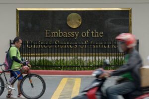 Commuters pass in front of the highly-secured US embassy in Manila on July 6, 2013. The United States issued a warning against travel to the southern Philippines, the embassy said, just days after Australia and Canada issued a similar advisory to their citizens, citing threats from criminal gangs and terrorist groups in the south, but not specifying any threat. AFP PHOTO / Jay DIRECTO