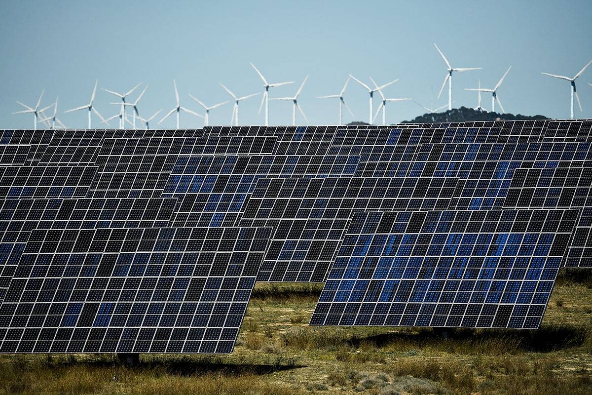 This photograph shows photovoltaic solar panels and windmills in the background around the Spanish Navarre town of Milagro on April 5, 2023. Spain generated record 50% of power from renewables in 2023, AFP reports on January 4, 2024. ANDER GILLENEA / AFP