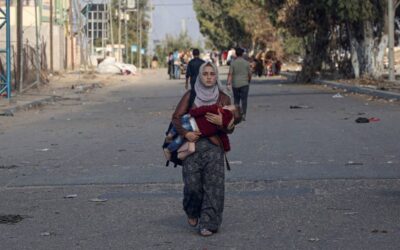 HRW Report Highlights Global Human Rights Suppression in 2023 A woman carries a child while heading toward southern Gaza. UNICEF/Eyad El Baba