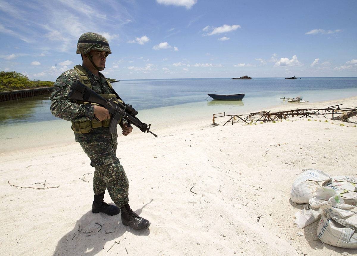This photo shows a Philippine soldier Tychico Octobre patrols a beach in Pagasa Island (Thitu Island) at the Spratly group of islands in the South China Sea, west of Palawan, on May 11, 2015. AFP PHOTO / POOL / RITCHIE B. TONGO