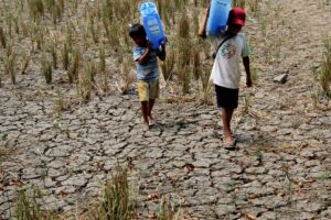 Childrens carry gallons of water as they walk through dried up rice fields in Bustos; Bulacan due to the lack of water from the irrigation sysytem. Angat and IPO dam that holds most of the water that supplies irrigation systems; are beginning to dried up due to the dry season as EL NINO approaches.