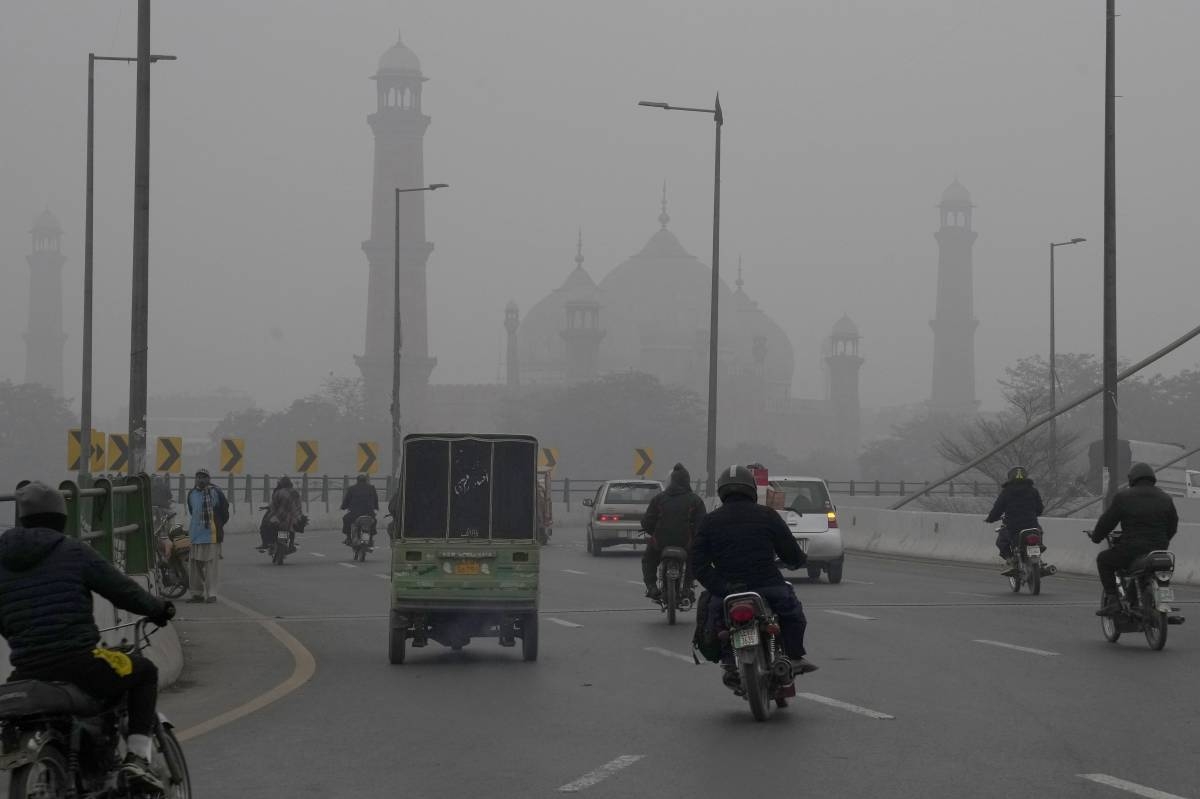 TOXIC AIR Motorcyclists and vehicles move on a bridge as smog envelops the historical Badshahi Mosque, background, in Lahore, Pakistan, Jan. 5, 2024. AP PHOTO