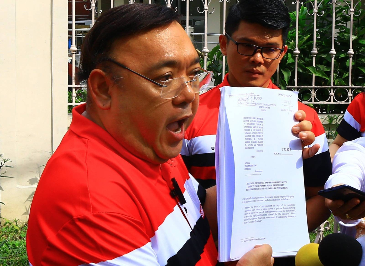 Former congressman and presidential spokesman, Harry Roque, in a Sonshine Media Network International (SMNI) uniform, together with reporters and anchors of SMNI shows a copy of the Petition for Certiorari and Prohibition for a Temporary Restraining Order in front of the Supreme Court in Manila, Tuesday, Jan. 30, 2024. The National Telecommunications Commission (NTC) suspended the operations of SMNI for alleged broadcasting violations. PHOTO BY MIKE ALQUINTO