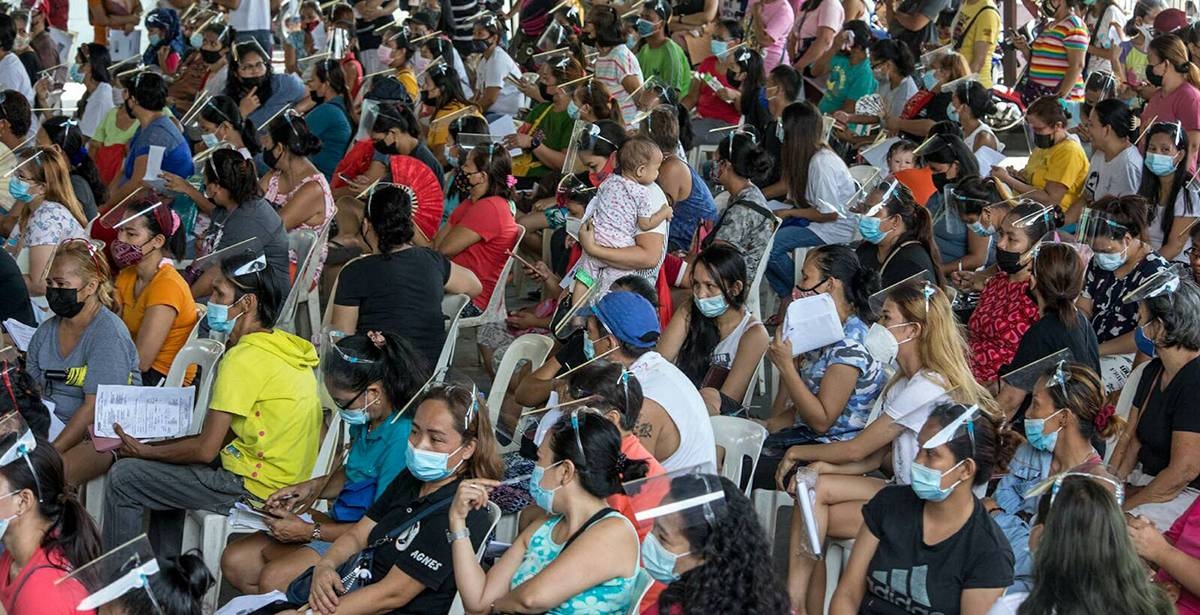 Residents of Barangay Pasong Tamo in Quezon City are herded at a covered court during the Department of Social Welfare and Development 4Ps’ — Pantawid Pamilyang Pilipino Program — verification of application for conditional cash grants to indigents on June 18, 2021. This is part of the government’s program to help the poorer population improve the health, nutrition and education of their children aged 0 to 18. The crowd, however, seemed to have forgotten about the pandemic as they failed to observe the health protocol on physical distancing to avoid Covid-19 infection. PHOTO BY RUY L. MARTINEZ