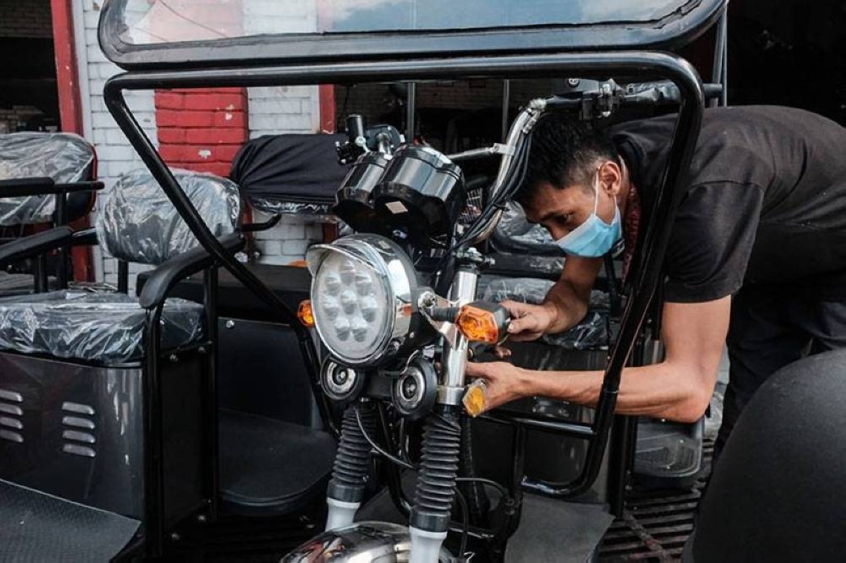 A technician checks an e-tricycle in a shop in Manila. The Department of Energy is keen on boosting the use of electric vehicles nationwide and will consult the public on this matter. PHOTO BY JOHN RYAN BALDEMOR
