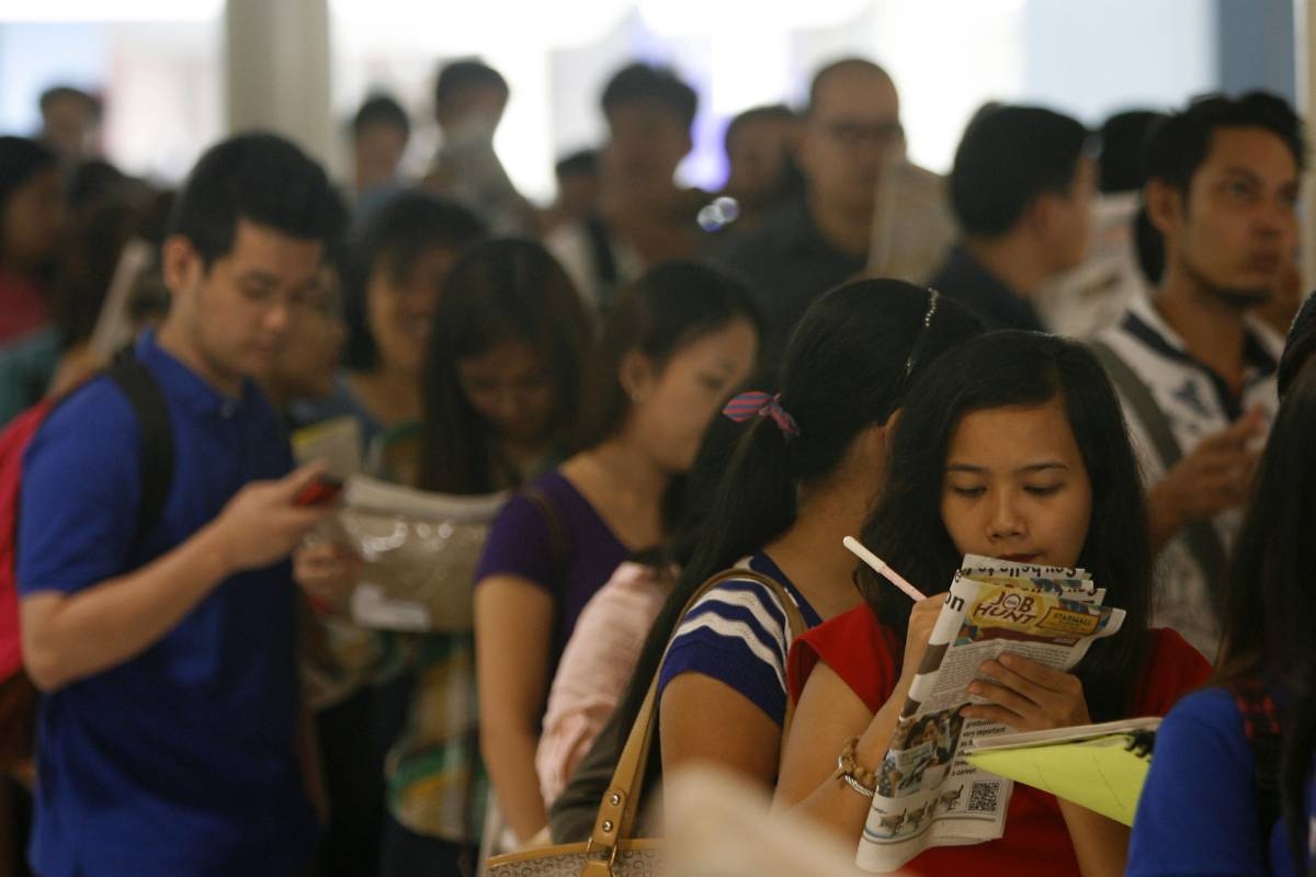 Job seekers fill out application forms while on line for a job fair at a mall in Mandaluyong City on Wednesday. About nine million or 19.1 Filipino adults are unemployed for the month of March, nearly eight percent down from the 27 percent or 12.4 million unemployed adults recorded last December, according to a recent survey by the Social Weather Stations. PHOTO BY MIGUEL DE GUZMAN