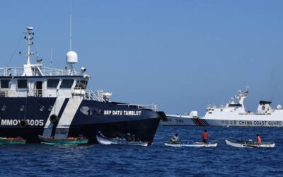 This photo taken on February 15, 2024 shows Filipino fishermen aboard their wooden boats queueing for free fuel beside the Philippine Bureau of Fisheries and Aquatic Resources (BFAR) ship BRP Datu Tamblot (L) as a Chinese coast guard ship (background R) monitors near the China-controlled Scarborough Shoal, in disputed waters of the South China Sea. The Philippines on February 17 accused Chinese coast guard vessels of "dangerous" manoeuvres for attempting to block a Filipino vessel dropping supplies to fishermen at a reef off the Southeast Asian nation's coast. (Photo by Ted ALJIBE / AFP) / “The erroneous mention[s] appearing in the metadata of this photo by Ted ALJIBE has been modified in AFP systems in the following manner: [At sea] instead of [Scarborough Shoal]. Please immediately remove the erroneous mention[s] from all your online services and delete it (them) from your servers. If you have been authorized by AFP to distribute it (them) to third parties, please ensure that the same actions are carried out by them. Failure to promptly comply with these instructions will entail liability on your part for any continued or post notification usage. Therefore we thank you very much for all your attention and prompt action. We are sorry for the inconvenience this notification may cause and remain at your disposal for any further information you may require.”