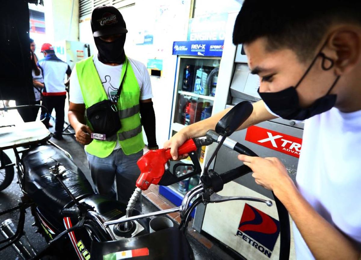 A guy filling up a motor tank