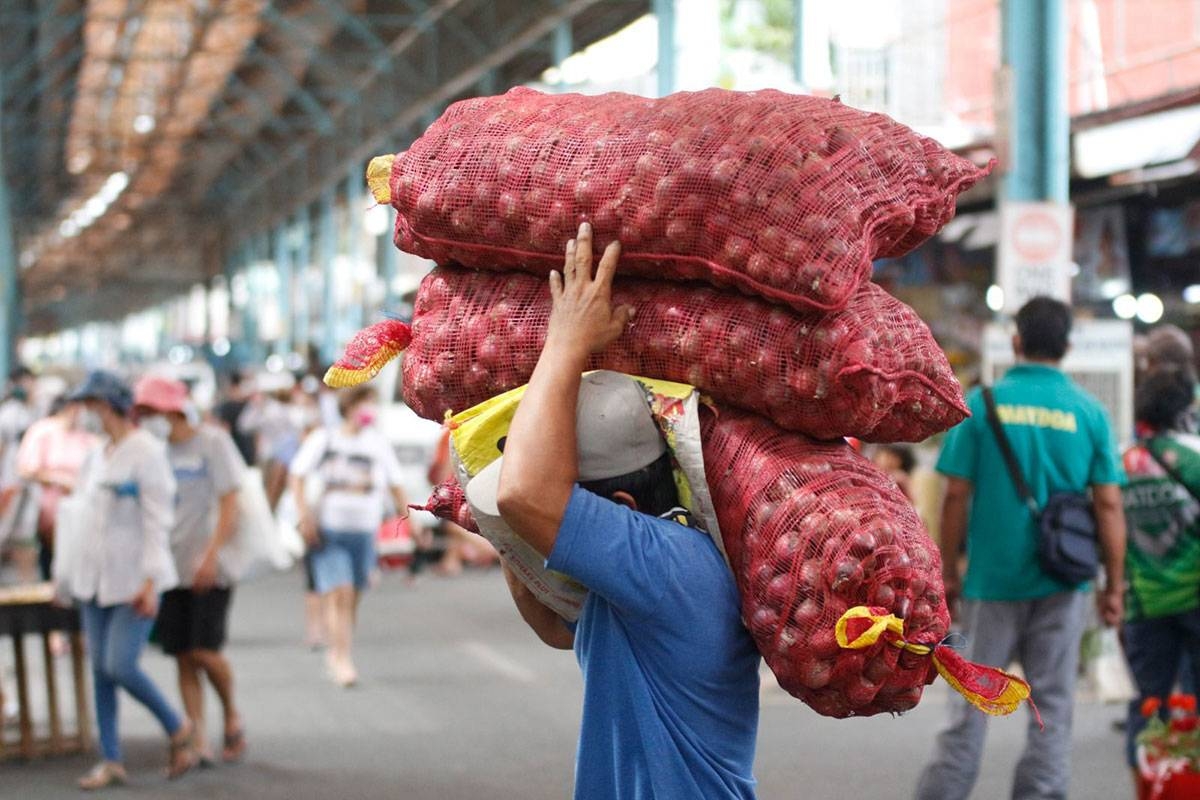 Workers unload sacks of Red onions as they delivered it to stores inside the Marikina public market. Photo by John Orven Verdote