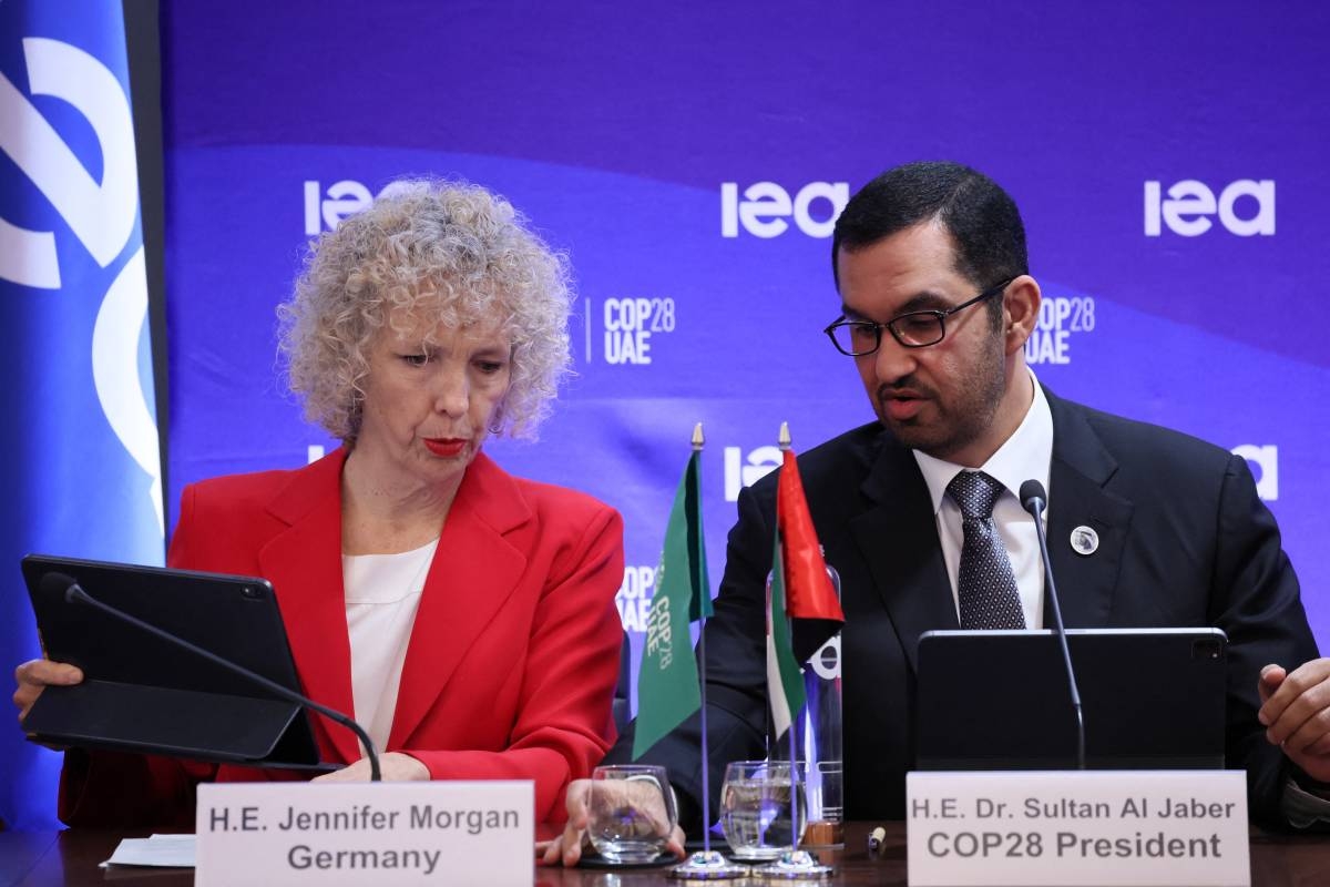 COP28 president Sultan Ahmed al-Jaber talks to State secretary and special envoy for intenational climate action German Jennifer Morgan (L) during a high-level round table on COP energy and climate commitments organised by the International Energy Agency (IEA) at its headquarters in Paris on February 20, 2024. The world needs 'trillions' of dollars to spur on the green transition and tackle global warming, the head of last year's COP28 climate talks said, warning that political momentum can evaporate without clear action. (Photo by ALAIN JOCARD / AFP)
