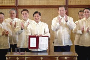 Signed President Ferdinand Marcos Jr. holds a copy of the Tatak Pinoy Act at the Ceremonial Hall in Malacañang on Monday, Feb. 26, 2024. PPA POOL PHOTO