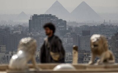 (From left) The Great Pyramid of Khufu (Cheops) and the Pyramids of Khafre (Chephren) and Menkaure (Menkheres) in Giza are visible in the background as a tourist walks at the promontory of the Cairo Citadel overlooking the skyline of Cairo and its twin city of Giza on February 19, 2024. AFP PHOTO