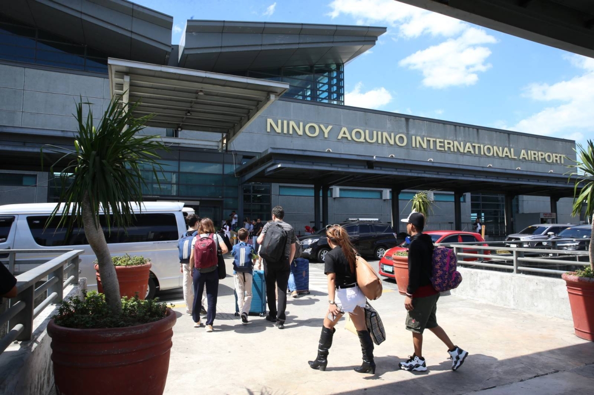 Passengers queue to enter the Ninoy Aquino International Airport terminal 3 in Pasay City on Saturday, February 24, 2024 while the airline staff carefully inspect their tickets. Ninoy Aquino International Airport (NAIA) was named the fourth worst gateway in Asia and the Middle East by business class travelers.  PHOTO BY RENE H. DILAN