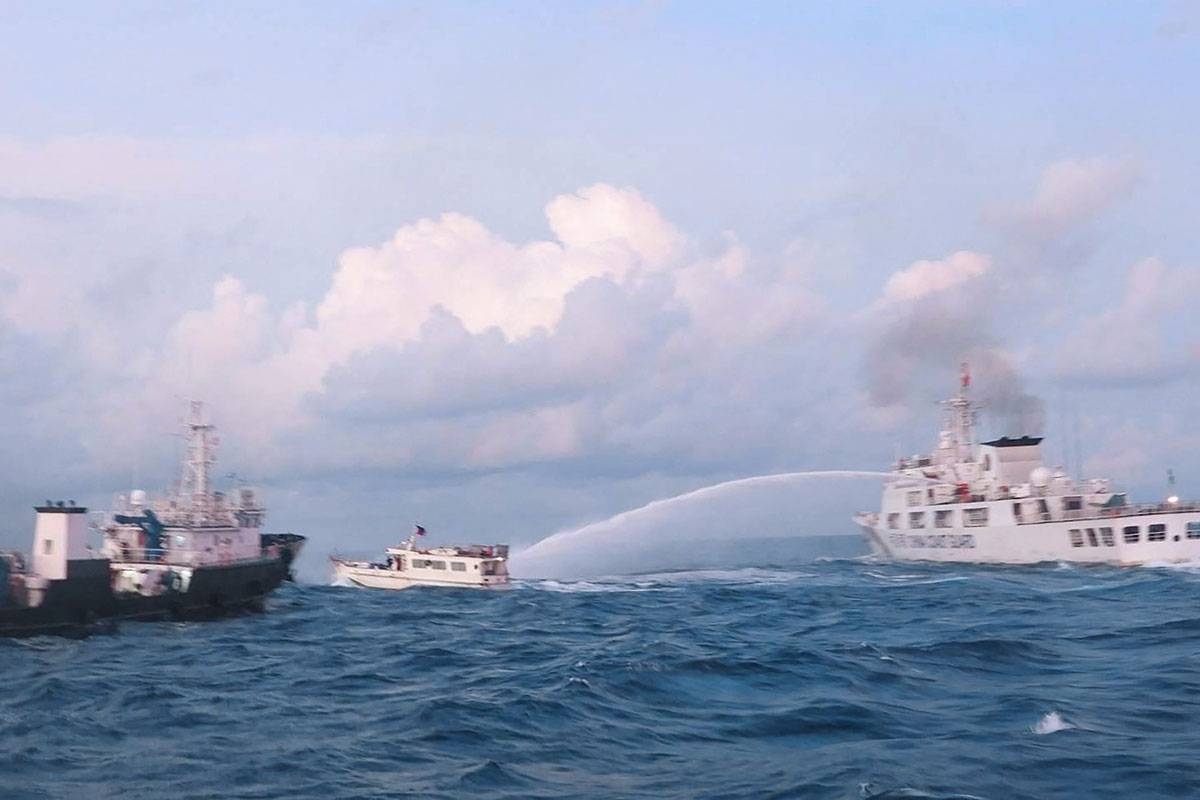 This handout photo taken and released on December 10, 2023 by the Philippine Coast Guard (PCG) shows a China Coast Guard vessel (R) using water cannon against the M/L Kalayaan chartered supply boat (C) during a mission to deliver provisions at Second Thomas Shoal in disputed waters of the South China Sea. A Philippine boat was 'rammed' by a Chinese coast guard ship during a resupply mission on December 10, the Philippine coast guard said, in the latest such confrontation in the disputed South China Sea. The Philippine Coast Guard also said a Chinese ship 'water cannoned' three Philippine vessels involved in the resupply mission, causing 'serious engine damage' to one of the boats. Handout / Philippine Coast Guard (PCG) / AFP