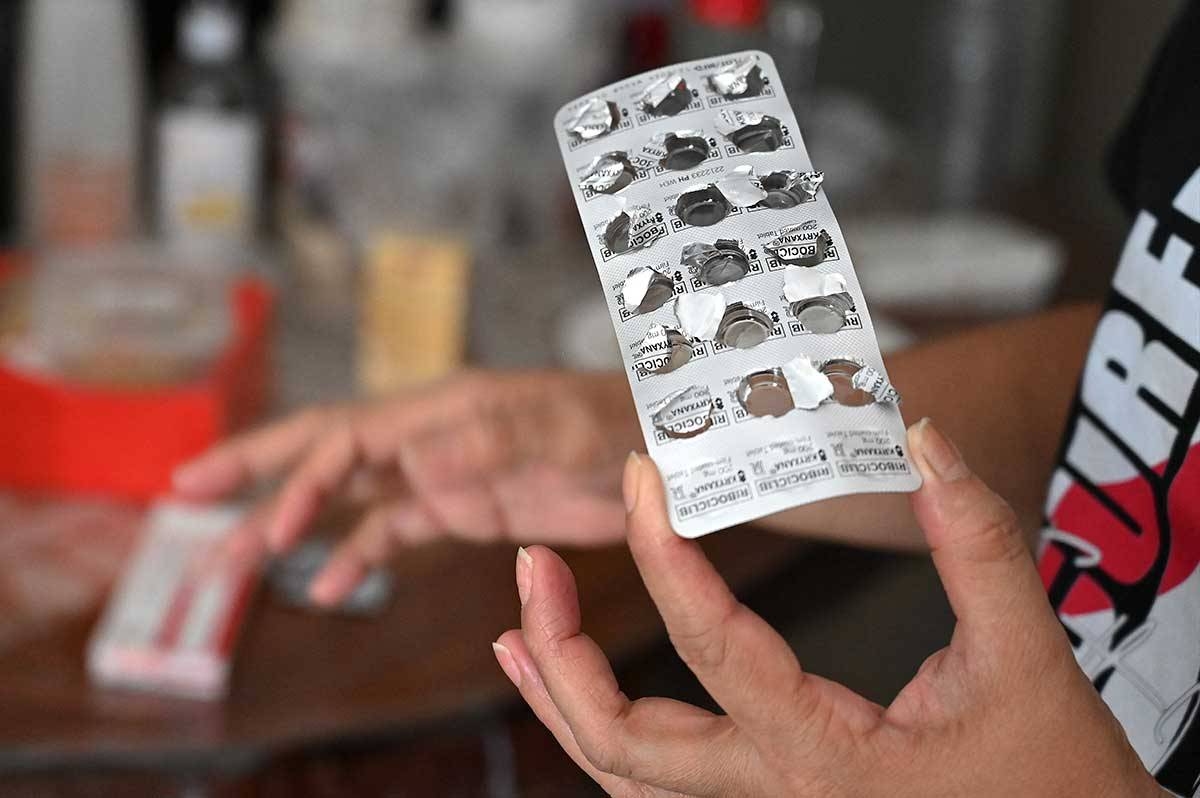 In this photo taken on November 20, 2023, Mary Ann Eduarte shows her medicines at her home in Montalban, Rizal. A shortage of doctors, difficulties of reaching a hospital in the archipelago, poor health literacy and fear of incurring huge medical bills have led many people suffering chronic conditions to seek alternative treatments online.
JAM STA ROSA / AFP