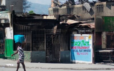 A woman walks past a drugstore burned by gang members during a protest in Port-au-Prince, Haiti, on March 12, 2024. AFP PHOTO