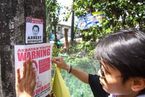 NO FAN A member of Akbayan Youth puts up posters calling for the arrest of Pastor Apollo Quiboloy in Quezon City on Monday, March 18, 2024. PHOTO BY JOHN ORVEN VERDOTE