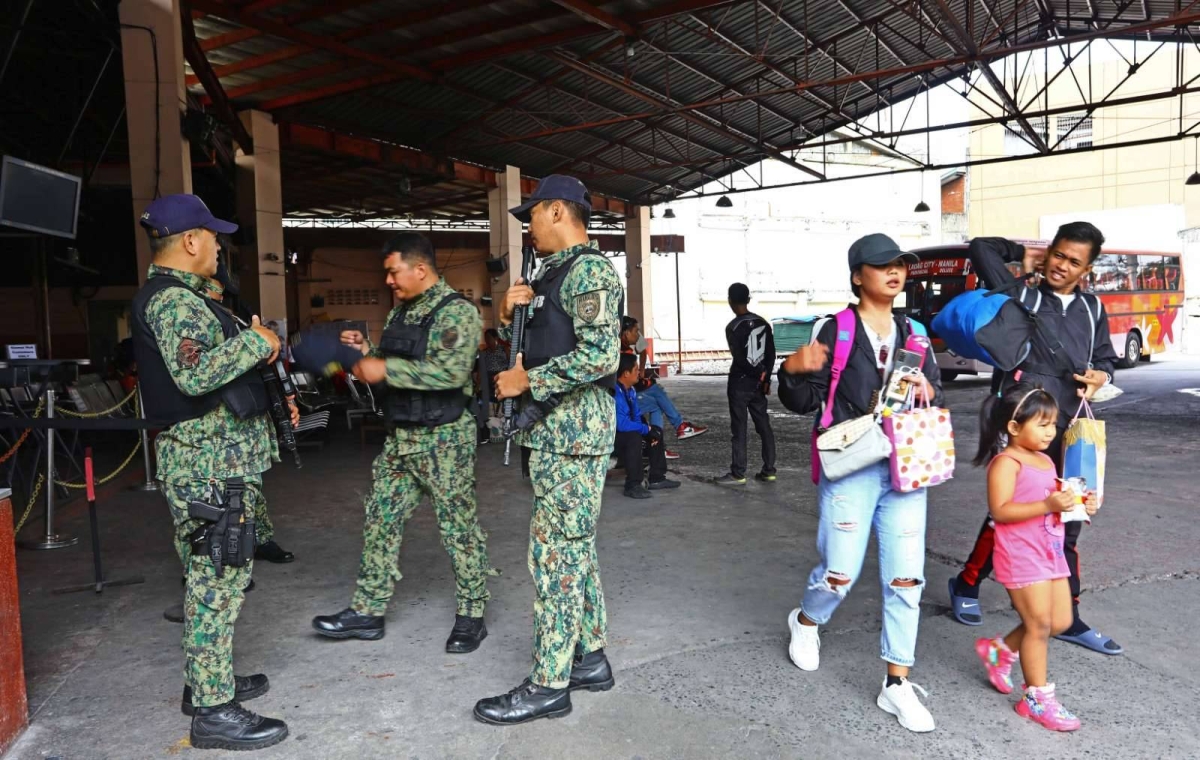 ON THEIR TOES Members of the Manila Police District and the Metropolitan Manila Development Authority guard a bus terminal in Sampaloc, Manila, on Monday, April 10, 2023, in anticipation of the influx of passengers coming back from their Holy Week break.  PHOTO BY MIKE ALQUINTO