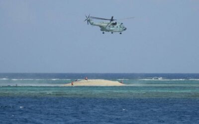 This handout photo taken on March 23, 2024 and received from the Philippine Bureau of Fisheries and Aquatic Resources (PCG/BFAR) on March 25, 2024 shows a Chinese helicopter hovering as Philippine scientists inspect a cay near the Philippine-held Thitu Island, in Spratly Islands, in the disputed South China Sea. AFP PHOTO /PHILIPPINE COAST GUARD/BUREAU OF FISHERIES AND AQUATIC RESOURCES (PCG/BFAR)
