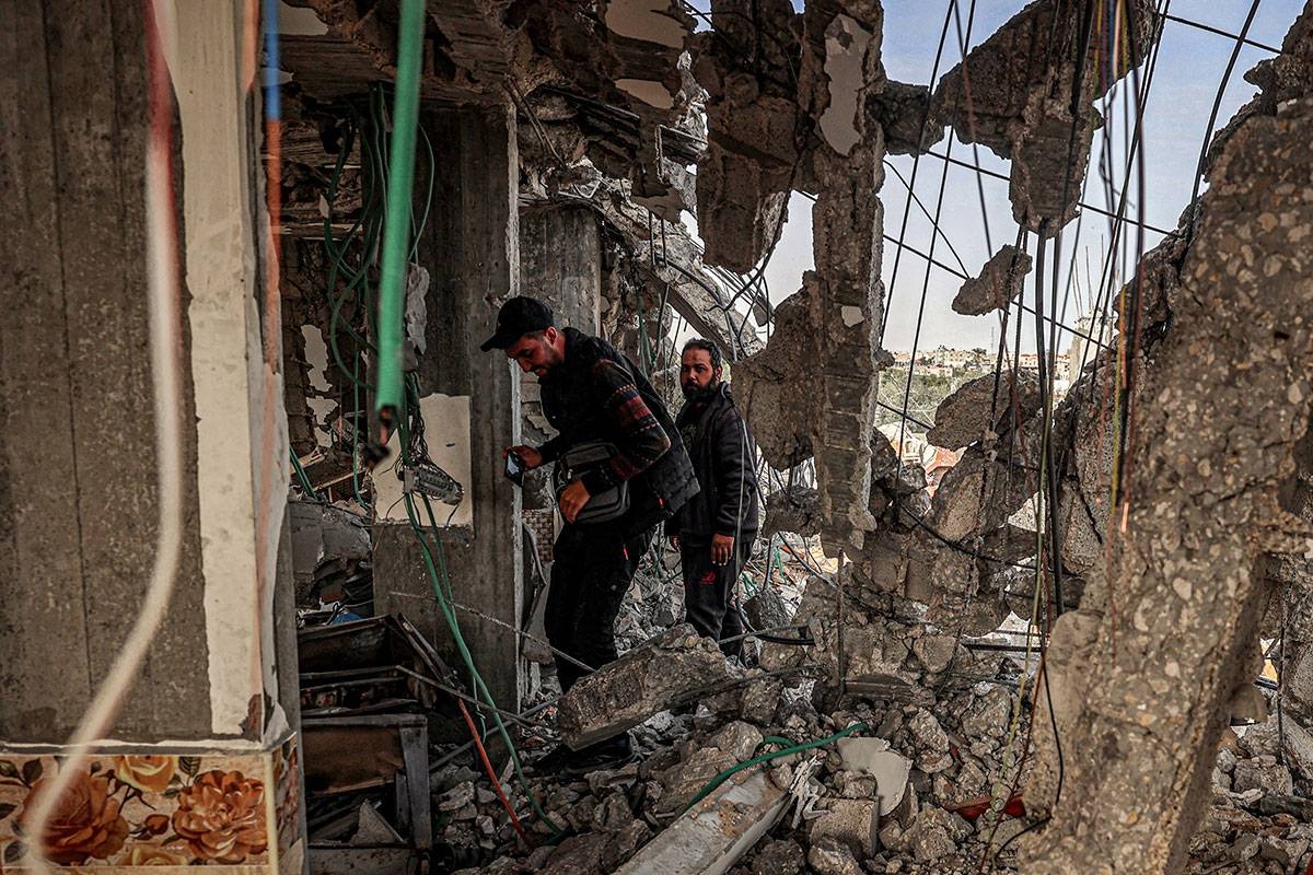 People inspect damage to a building that was hit overnight during Israeli bombardment in Rafah in the southern Gaza Strip on March 26, 2024 amid the ongoing conflict in the Palestinian territory between Israel and the militant group Hamas. SAID KHATIB / AFP