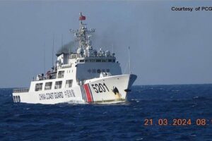 In this handout frame grab video footage taken on March 21, 2024 and received from Philippine Coast Guard (PCG) on March 22, shows a Chinese Coast Guard ship shadowing a Philippine Coast Guard ship (not pictured) near Sandy Cay reef, near the Philippine-held Thitu Island in Spratly Islands, in the disputed South China Sea. The Philippine Coast Guard on March 22 accused a Chinese vessel of "dangerous manoeuvres" as it attempted to block Filipino scientists from reaching a reef in the South China Sea. Handout / Philippine Coast Guard (PCG) / AFP