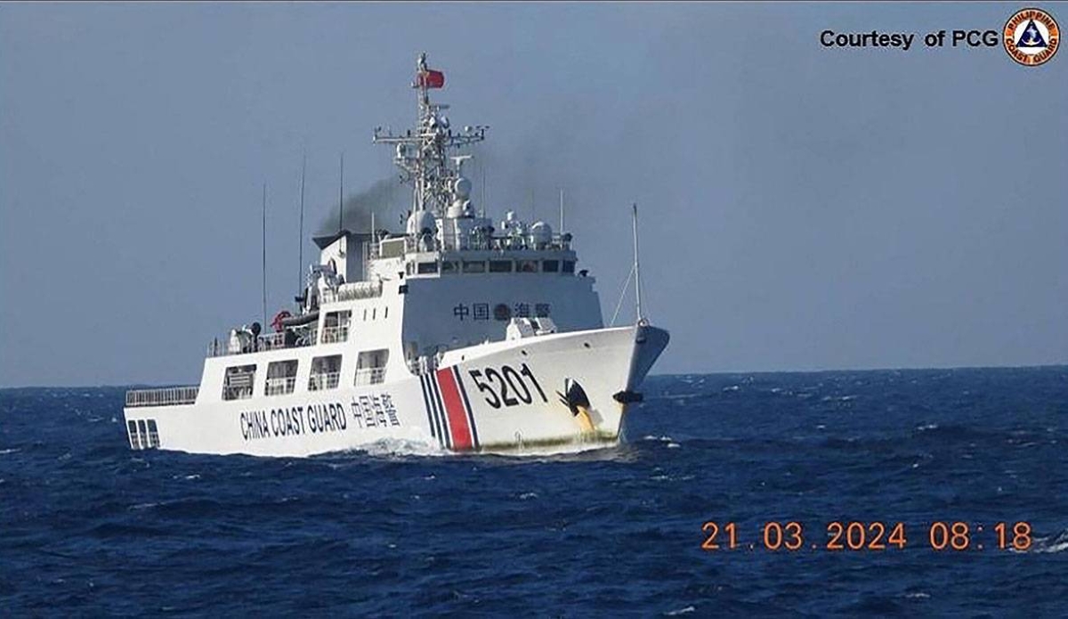 In this handout frame grab video footage taken on March 21, 2024 and received from Philippine Coast Guard (PCG) on March 22, shows a Chinese Coast Guard ship shadowing a Philippine Coast Guard ship (not pictured) near Sandy Cay reef, near the Philippine-held Thitu Island in Spratly Islands, in the disputed South China Sea. The Philippine Coast Guard on March 22 accused a Chinese vessel of "dangerous manoeuvres" as it attempted to block Filipino scientists from reaching a reef in the South China Sea. Handout / Philippine Coast Guard (PCG) / AFP