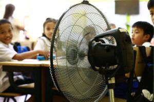 Students of the Justo Lukban Elementary School in Paco, Manila on Tuesday, April 2, 2024, gather near electric fans to cool themselves while in class. PHOTOS BY MIKE ALQUINTO