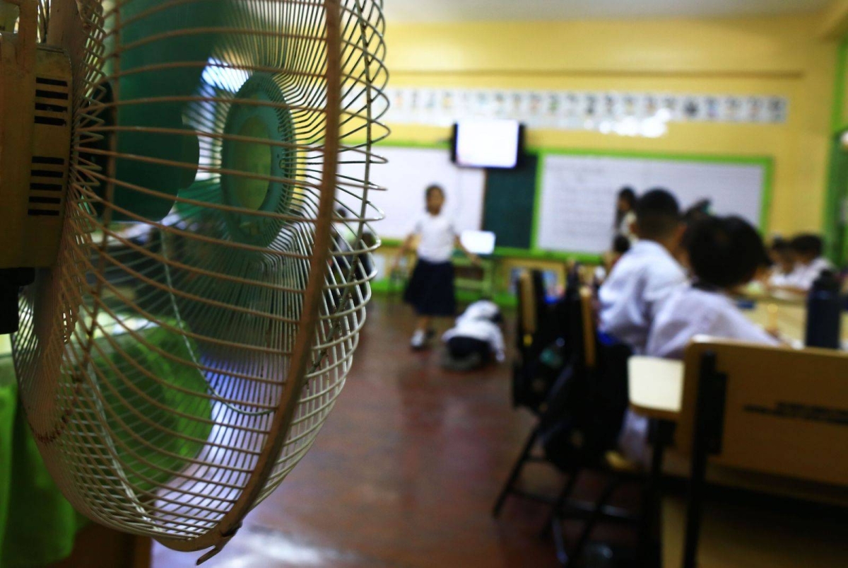 Students of the Justo Lukban Elementary School in Paco, Manila on Tuesday, April 2, 2024, gather near electric fans to cool themselves while in class. PHOTOS BY MIKE ALQUINTO