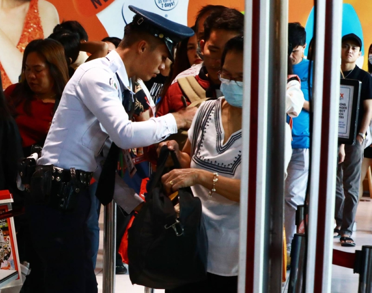 BACK IN THE CITY A security guard checks the bags of passengers returning to Manila after spending their Holy Week break in the provinces, at the Parañque Integrated Terminal Exchange in Parañaque City, on Monday, April 1, 2024. PHOTO BY MIKE ALQUINTO