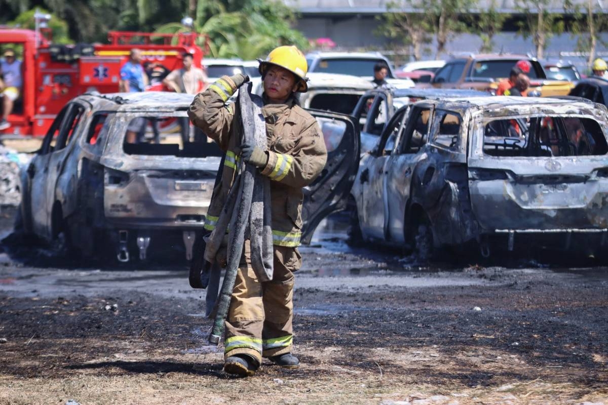 NAIA FIRE A fire fighter rests after helping put out the fire that damaged 19 vehicles at the parking area of the Ninoy Aquino International Airport Monday. Authorities attributed the conflagration to grass fire. PHOTO BY J. GERARD SEGUIA
