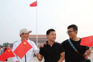 Three men hold Chinese national flags at Tiananmen Square in Beijing on Tuesday after the flag-raising ceremony. GLOBAL TIMES PHOTO