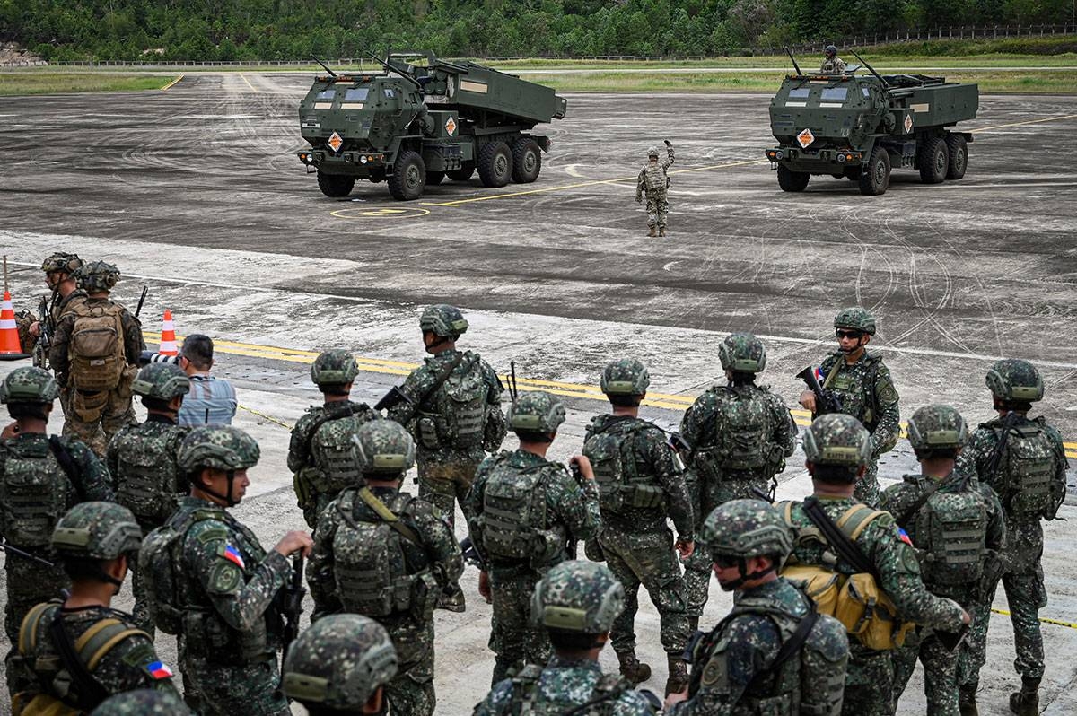 Soldiers look on as High Mobility Artillery Rocket System (HIMARS) batteries arrive for an airfield seizure exercise as part of the US-Philippines Balikatan joint military exercise at San Vicente Airport in Palawan on May 1, 2024. JAM STA ROSA / AFP