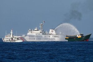 This photo taken on March 5, 2024 shows China Coast Guard vessels deploying water cannons at the Philippine military chartered Unaizah May 4 (R) during its supply mission to Second Thomas Shoal in disputed waters of the South China Sea.  JAM STA ROSA / AFP